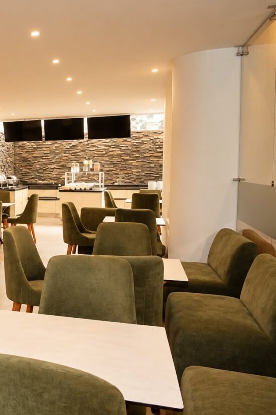Salón del restaurante con mesas y sillones en Hotel BGA Bucaramanga